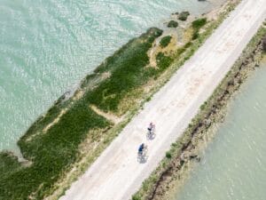 persone che pedalano lungo ciclabile bordo mare